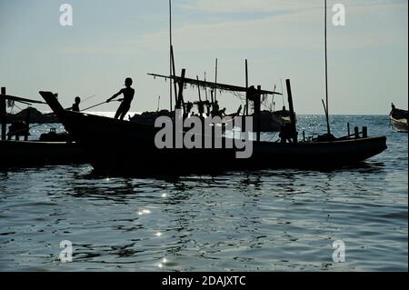 Silhouetten der birmanischen Fischer bereit ihre Fischerboote für eine Nächte Angeln als die Sonne untergeht auf Ngapali Strand Myanmar Stockfoto