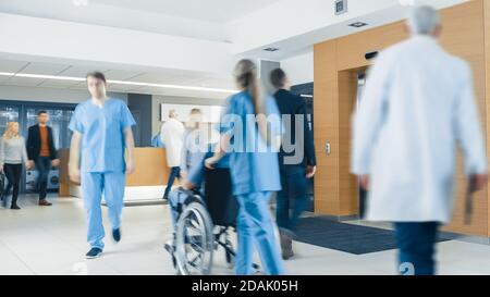 Krankenhausfoyer. Ärzte, Krankenschwestern, Hilfspersonal und Patienten, die in der Lobby der medizinischen Einrichtung arbeiten und gehen. Stockfoto