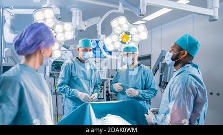 Vielfältiges Team von professionellen Chirurgen, Assistenten und Krankenschwestern, die invasive Chirurgie an einem Patienten im Operationssaal des Krankenhauses durchführen. Chirurgen Haben Stockfoto