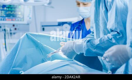 Im Operationssaal des Krankenhauses Diverse Team von professionellen Chirurgen und Krankenschwestern Naht Wunde nach erfolgreicher Operation. Stockfoto