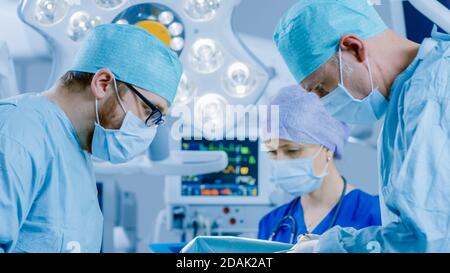 Im Operationssaal des Krankenhauses Diverse Team von professionellen Chirurgen und Krankenschwestern Naht Wunde nach erfolgreicher Operation. Stockfoto