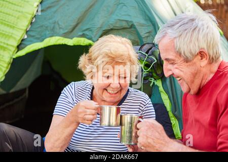 Ein glückliches älteres Paar, das vor dem Hotel einen Kaffee am Morgen getrunken hat Zelt in der Natur Stockfoto