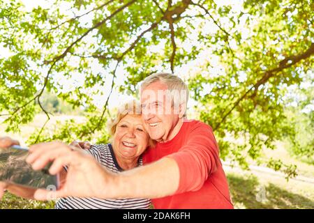 Glückliches Seniorenpaar macht ein Selfie-Foto auf einer Reise Im Park im Sommer Stockfoto