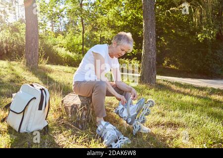 Ältere Frau auf Inline-Skates im Sommer in Natur vor Inline Skating Stockfoto