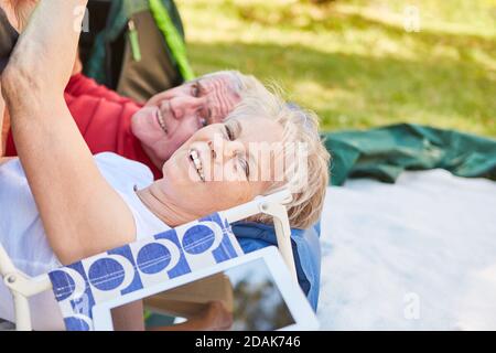 Vital Senior Paar entspannen zusammen während Camping in der Natur auf Urlaub Stockfoto