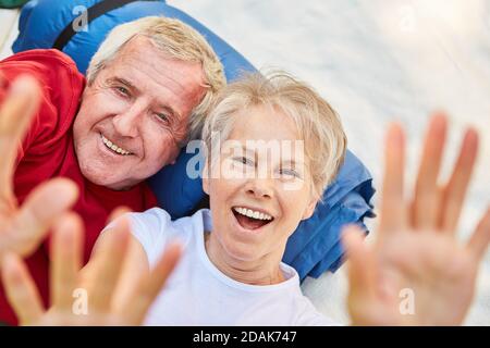 Fröhliches Rentnerpaar hat Spaß beim Campen und Winken An der Kamera Stockfoto