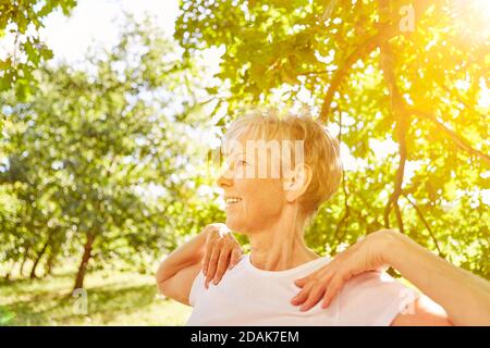 Glücklich aktive ältere Frau tun Gymnastik Sport im Freien in der Natur Stockfoto