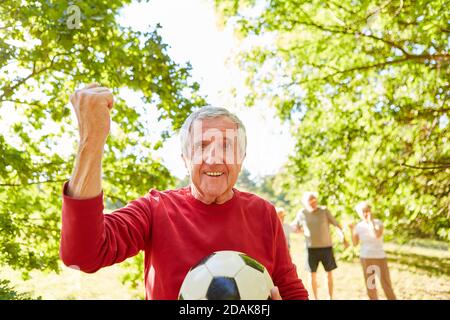 Vitaler älterer Mann mit geballter Faust als Sieger nach Ein Fußballspiel im Park Stockfoto