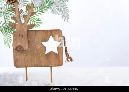 Weihnachtshirsch aus Holz mit Tannenbaum auf Schnee. Weihnachten oder Neujahr Konzept Stockfoto