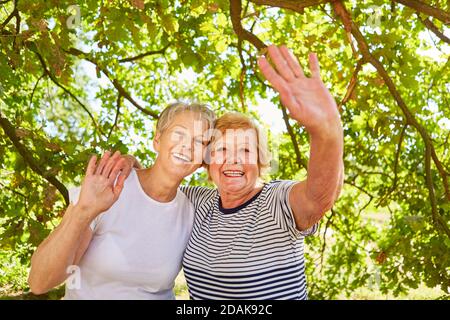 Glückliche ältere Frauen als beste Freunde winken auf einen Sommer Ausflug Stockfoto