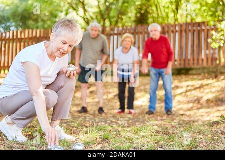 Gruppe von Senioren als Rentner spielen Boule im Garten Bei einem Wettbewerb Stockfoto