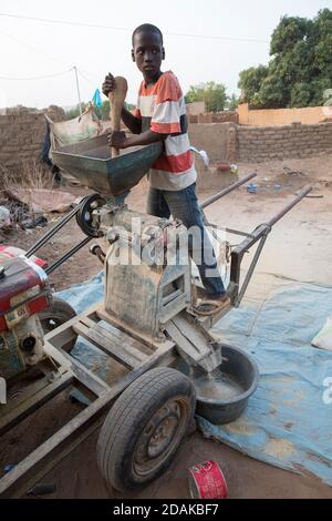 Selingue, Mali, 27. April 2015; Reissentälung. Adama Tankara, 12, arbeitet mit seinem Bruder zusammen. Die Maschine gehört ihnen. Stockfoto