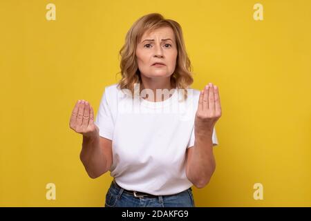 Reife Frau tut italienische Geste mit Hand und Fingern versuchen, ihren Standpunkt zu erklären. Stockfoto