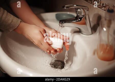 Waschen der Hände mit der Seife unter dem Kran mit dem Wasser. Hygiene Hände im Badezimmer. Virus stoppen. Stockfoto