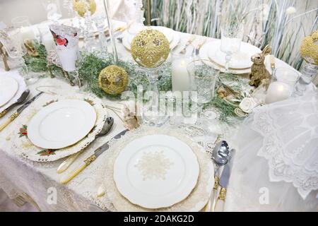 Silvesterdinner. Schön servierte Tische. Weißes Geschirr und Tischdecke aus Spitze. Sauberes Besteck. Stockfoto