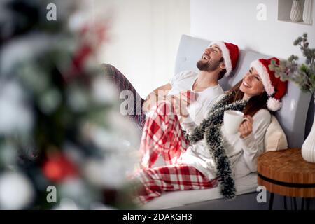 Glückliches Paar zusammen in einem Bett an einem Weihnachtsmorgen Stockfoto