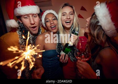 Gruppe von Freunden auf Neujahr Party, Alkohol trinken, tragen weihnachtsmützen Stockfoto