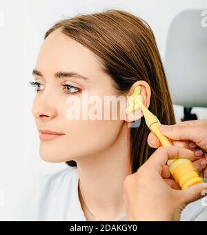 Persönlich geformte Ohrstöpsel. Prozess der Herstellung von Ohrstöpsel aus einem Eindruck eines einzelnen s Frau Ohr. Audiologie. Teil des Sets Stockfoto