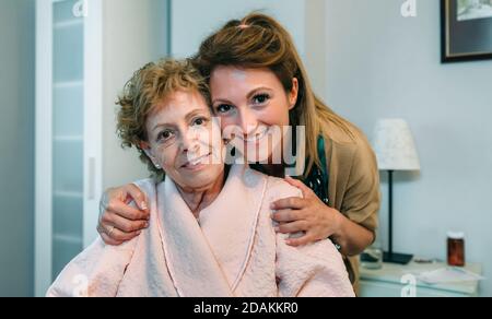 Liebevolle Hausmeister posiert mit älteren Patienten Stockfoto