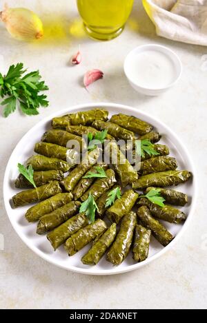 Dolma, gefüllte Traubenblätter mit Reis und Fleisch auf hellem Steintisch. Nahaufnahme Stockfoto