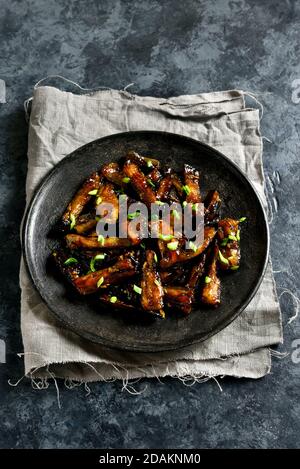 Bulgogi Aubergine auf Teller auf dunklem Steingrund unter Rühren braten. Gebratene Aubergine im koreanischen Stil. Nahaufnahme Stockfoto