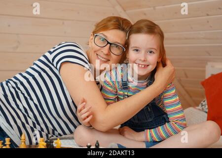 Das kleine Mädchen und ihre Mutter lächeln. Porträt einer Tochter und Mutter Stockfoto