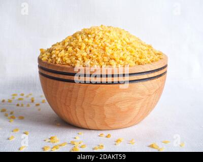 Getrocknete Bulgur Weizen in Holzschale. Verschüttete Bulgur. Stockfoto