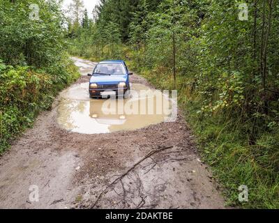 Das Auto geht durch den Regen verwischt die Straße. Das Auto im Regen verwischte die Straße. Stockfoto