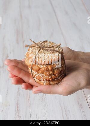 Hände mit einem Stapel frischer Sesamkekse. Stockfoto