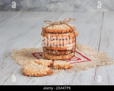 Ein Stapel köstlicher frischer Sesamkekse auf einem weißen Holztisch. Stockfoto