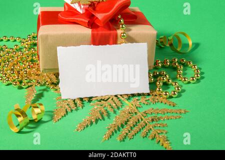 Weihnachtskarte Mockup Vorlage mit Geschenk goldene festliche Dekoration auf grünem Hintergrund. Design-Element für Weihnachten und Neujahr Gratulation, rs Stockfoto