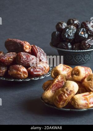 Arabische Datteln Früchte sind auf einem dunklen Tisch ausgelegt. Stockfoto