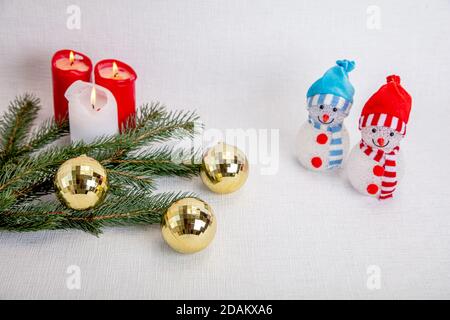 Dekorative Schneemänner für das neue Jahr, Kerzen, Tannenzweig, medizinische Maske. Konzept, Weihnachten in der Coronavirus-Epidemie, gratulieren Freunden, aber bleiben Sie in Corantin. Hochwertige Fotos Stockfoto