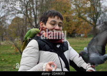 Junge Person lachend Vögel versuchen, auf ihr zu sitzen Stockfoto