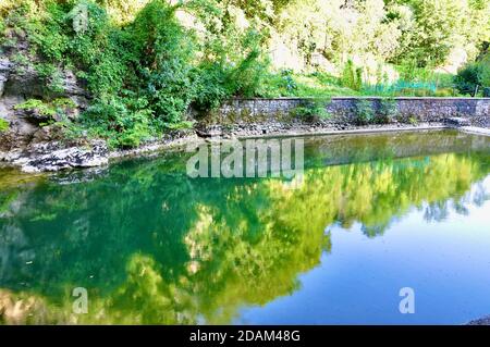 Bäume spiegeln sich auf der Wasseroberfläche des Flusses. Spiegelung von Bäumen auf der Wasseroberfläche des Flusses im Frühlingswald. Stockfoto