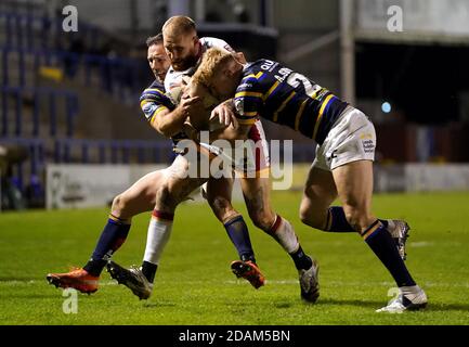 Sam Tomkins von Catalans Dragons wird von Alex Sutcliffe von Leeds Rhinos (rechts) während des Betfred Super League Play-Off-Spiels im Halliwell Jones Stadium, Warrington, angegangen. Stockfoto