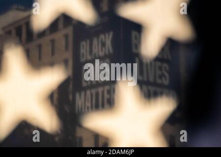 Washington, Usa. November 2020. Ein Black-Lives-Matter-Zeichen wird durch eine amerikanische Flagge als Unterstützer von US-Präsident Donald Trump und diejenigen gegen Trump am Freitag, 13. November 2020, auf dem BLM Plaza in der Nähe des Weißen Hauses in Washington, DC, gesehen. Anhänger von Trump behaupten, er sei immer noch der Gewinner und werde weitere 4 Jahre weitermachen. Foto von Ken Cedeno/UPI Kredit: UPI/Alamy Live Nachrichten Stockfoto