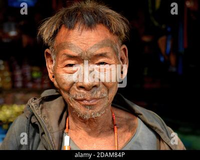 Alt pensionierten indischen Konyak Naga Krieger und Headhunter mit unverwechselbaren Tribal Gesichts-Tattoo und traditionelle Frisur Posen für die Kamera. Stockfoto