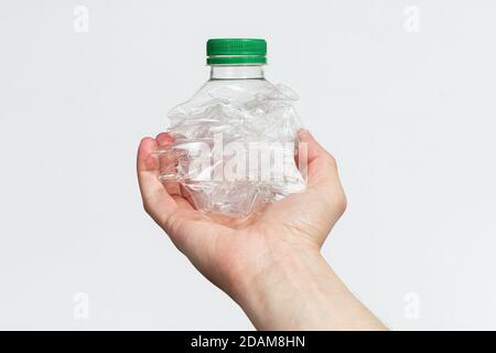 Hand halten zerschlagen leere Plastikflasche isoliert auf einem weißen Hintergrund Stockfoto