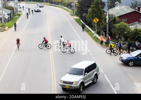 LA CALERA KOLUMBIEN - OKTOBER, 2020: Gruppe von Amateurradfahrern, die die Straße zwischen Bogota und La Calera auf den Bergen in Kolumbien überqueren Stockfoto