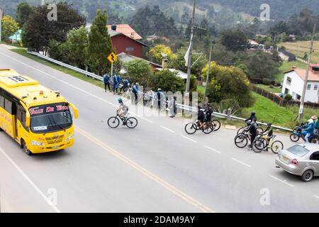 LA CALERA KOLUMBIEN - OKTOBER, 2020: Gruppe von Amateurradfahrern, die die Straße zwischen Bogota und La Calera auf den Bergen in Kolumbien überqueren Stockfoto