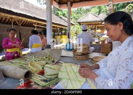 Balinesische Frauen, die kleine Körbe für religiöse Darbringung im Gunung Kawi Tempelkomplex, Tampaksiring, Bali, Indonesien, anklagend Stockfoto