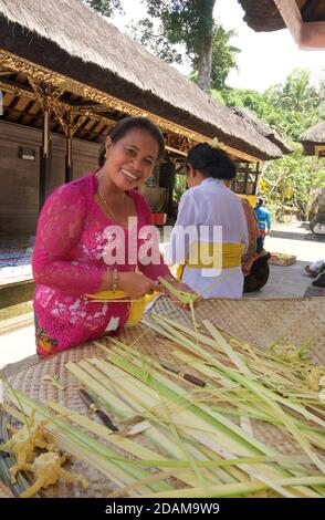 Balinesische Frauen, die kleine Körbe für religiöse Darbringung im Gunung Kawi Tempelkomplex, Tampaksiring, Bali, Indonesien, anklagend Stockfoto