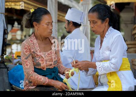 Balinesische Frauen, die kleine Körbe für religiöse Darbringung im Gunung Kawi Tempelkomplex, Tampaksiring, Bali, Indonesien, anklagend Stockfoto