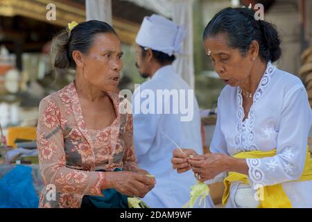 Balinesische Frauen, die kleine Körbe für religiöse Darbringung im Gunung Kawi Tempelkomplex, Tampaksiring, Bali, Indonesien, anklagend Stockfoto