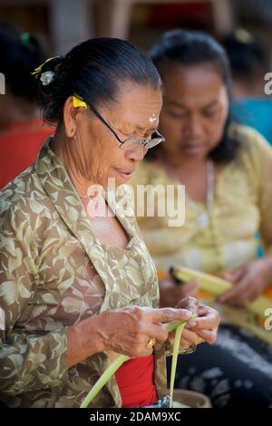 Balinesische Frauen, die kleine Körbe für religiöse Darbringung im Gunung Kawi Tempelkomplex, Tampaksiring, Bali, Indonesien, anklagend Stockfoto