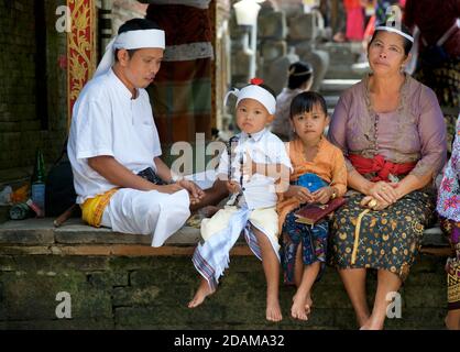 Balinesische Familie entspannen im Tirta Empul Tempel während Galungan Feiern, Bali, Indonesien Stockfoto