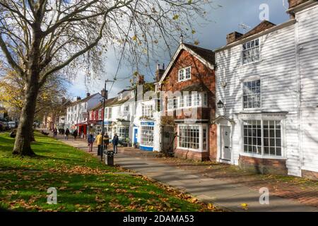 Menschen, die an einem sonnigen Herbsttag auf dem breiten Bürgersteig der Tenterden High Street spazieren, Kent, Großbritannien Stockfoto