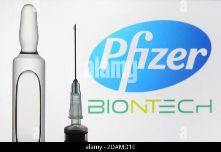 In dieser Abbildung sehen Sie eine Spritze und eine Ampulle vor dem amerikanischen multinationalen Pharmakonzern Pfizer und dem deutschen Biotechnologie-Unternehmen BioNTech Logos. Stockfoto