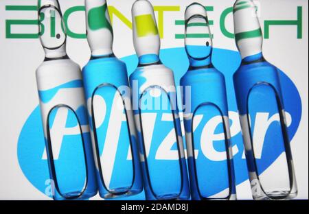 In dieser Abbildung sind Ampullen vor dem amerikanischen multinationalen Pharmakonzern Pfizer und dem deutschen Biotechnologie-Unternehmen BioNTech Logos zu sehen. Stockfoto